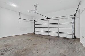 Eine Garage mit einer Metalldoortür, Betonboden und weißen Wänden.