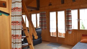 Un interior de madera con una escalera, un sofá y una cama.