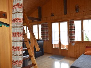 Ein Holzinnenraum mit Treppe, einer Couch und einem Bett.