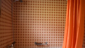 Un baño con bañera, ducha y toallero.