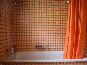 Ein Badezimmer mit Badewanne, Dusche und Handtuchhalter.