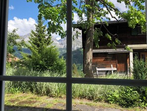 A rustic cabin with a wooden exterior, surrounded by lush greenery and mountains in the background. - Sunnegruess UG Appartement/Fewo, Dusche, WC 1.5 Zimmerwohnung by Interhome (Adelboden)