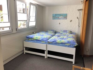 A small, single-bed room with a window, a painting on the wall, and a floor lamp. - Sunnegruess UG Appartement/Fewo, Dusche, WC 1.5 Zimmerwohnung by Interhome (Adelboden)
