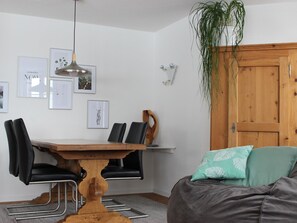 A dining area with a wooden table, black chairs, and a hanging pendant light. - Surselva Appartement/Fewo, Dusche, WC, Balkon 6-Zimmerwohnung by Interhome (Adelboden)