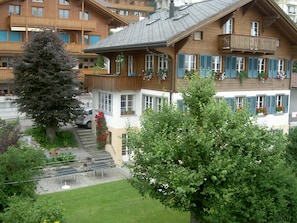 A multi-story wooden building with balconies, windows with shutters, and a well-maintained garden. - Surselva Appartement/Fewo, Dusche, WC, Balkon 6-Zimmerwohnung by Interhome (Adelboden)