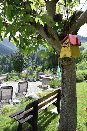 A bench under a tree with a birdhouse attached to the trunk. - Gästehaus Alpengruss Appartement/Fewo, Dusche, WC, 1 Schlafraum by Interhome (Adelboden)