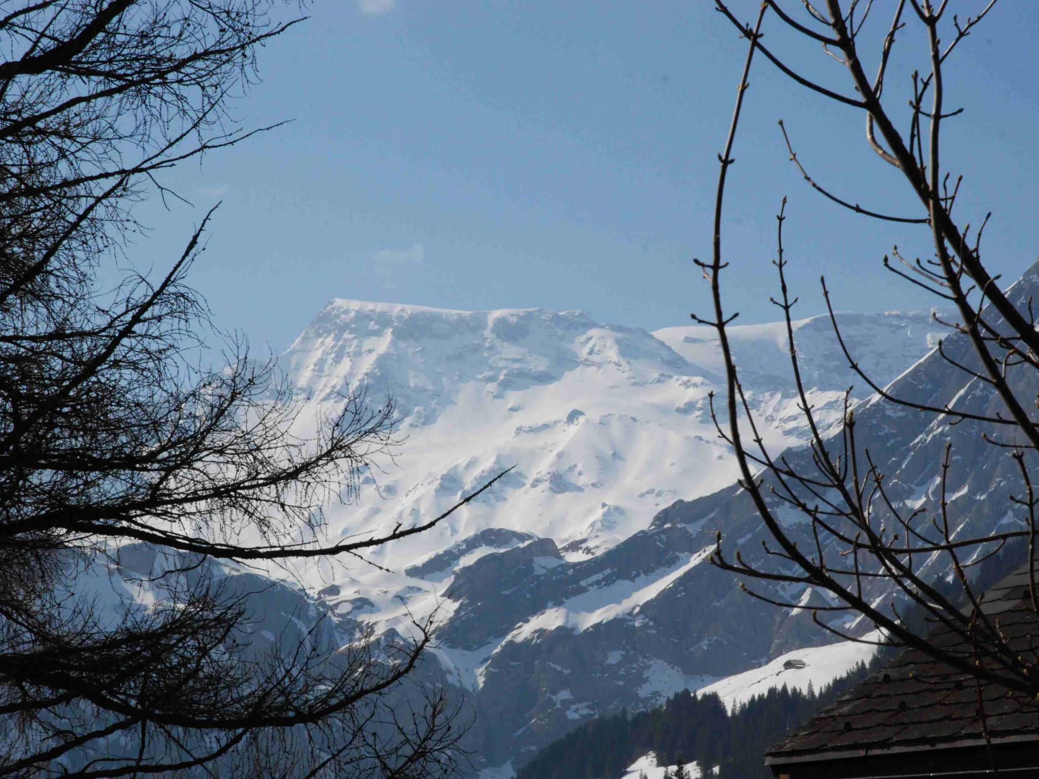A mountain landscape with snow-covered peaks and a clear sky.