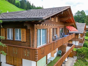A multi-story wooden chalet with balconies, large windows, and a sloped roof. - Ravinel 2 Appartement/Fewo, Dusche, WC, 3 Schlafräume 4-Zimmerwohnung by Interhome (Adelboden)