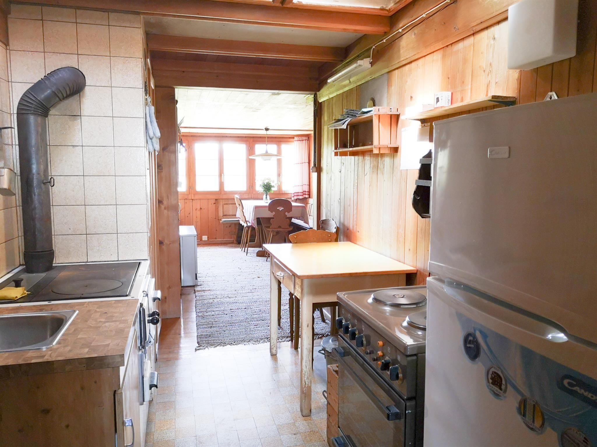 Cocina compacta con estufa, pileta y un refrigerador grande.