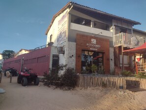 Ein Gebäude mit einem Schild für Rotacome3, das einen Balkon und ein rotes Markisenvorzelt zeigt.