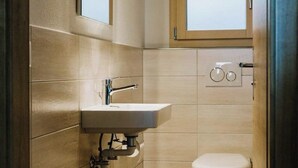 Un baño pequeño con lavamanos, espejo e inodoro.