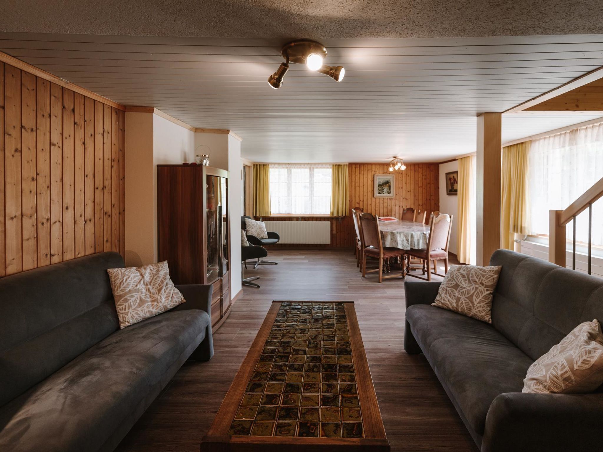 Una sala de estar acogedora con dos sofás, una mesa de centro y un comedor con mesa y sillas.