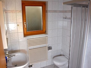 Ein Badezimmer mit Waschbecken, Toilette und Dusche.