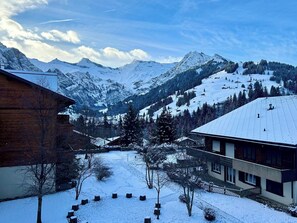 Eine verschneite Berglandschaft mit einem Skigebiet im Hintergrund.