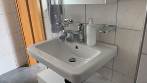 Ein Badezimmer mit Waschbecken, Spiegel und Handtuchhalter.