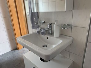 Ein Badezimmer mit Waschbecken, Spiegel und Handtuchhalter.
