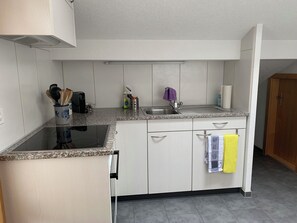 Une cuisine compacte équipée d’une cuisinière intégrée, d’un évier et d’un lave-vaisselle.
