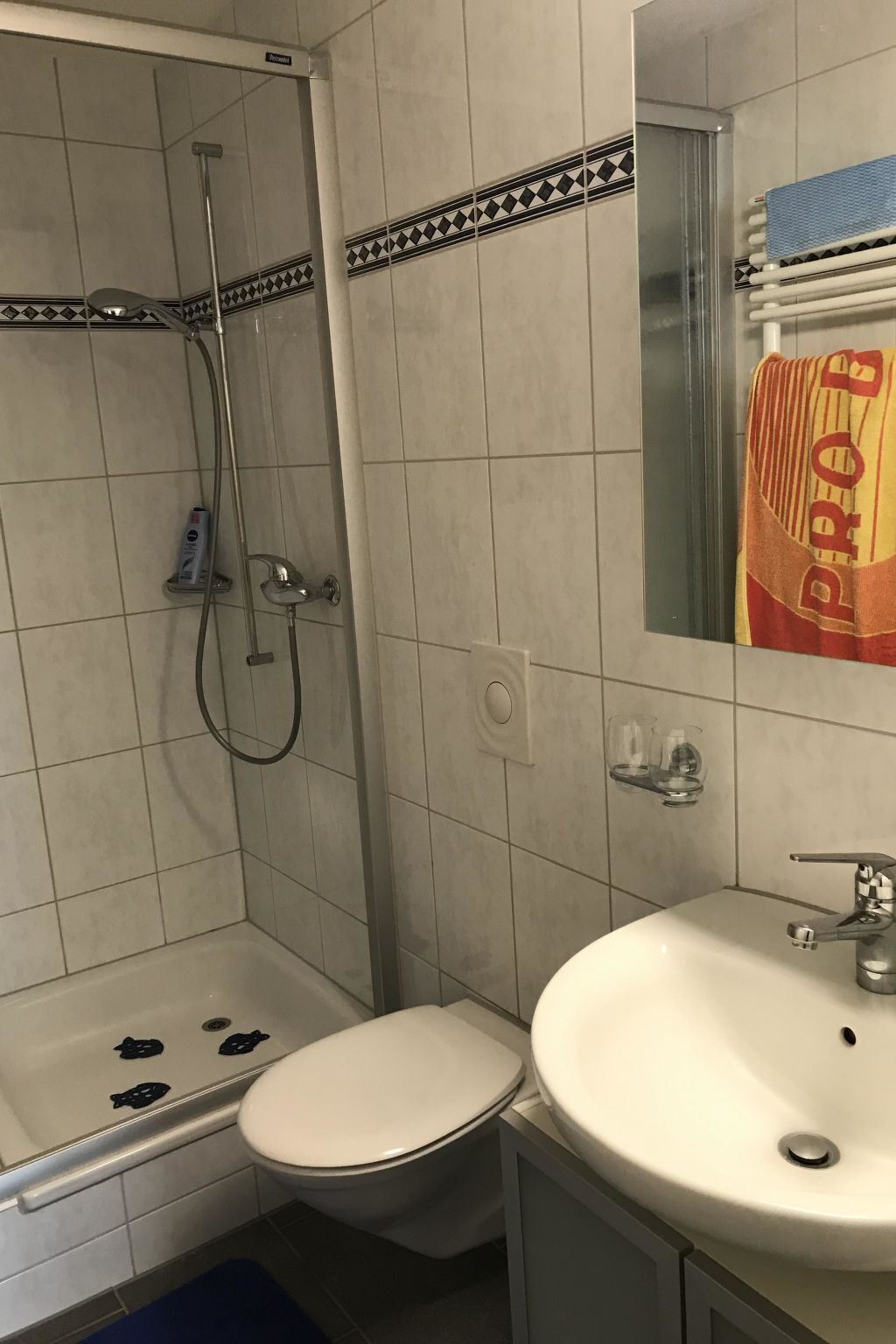 A bathroom with a shower, toilet, and sink.