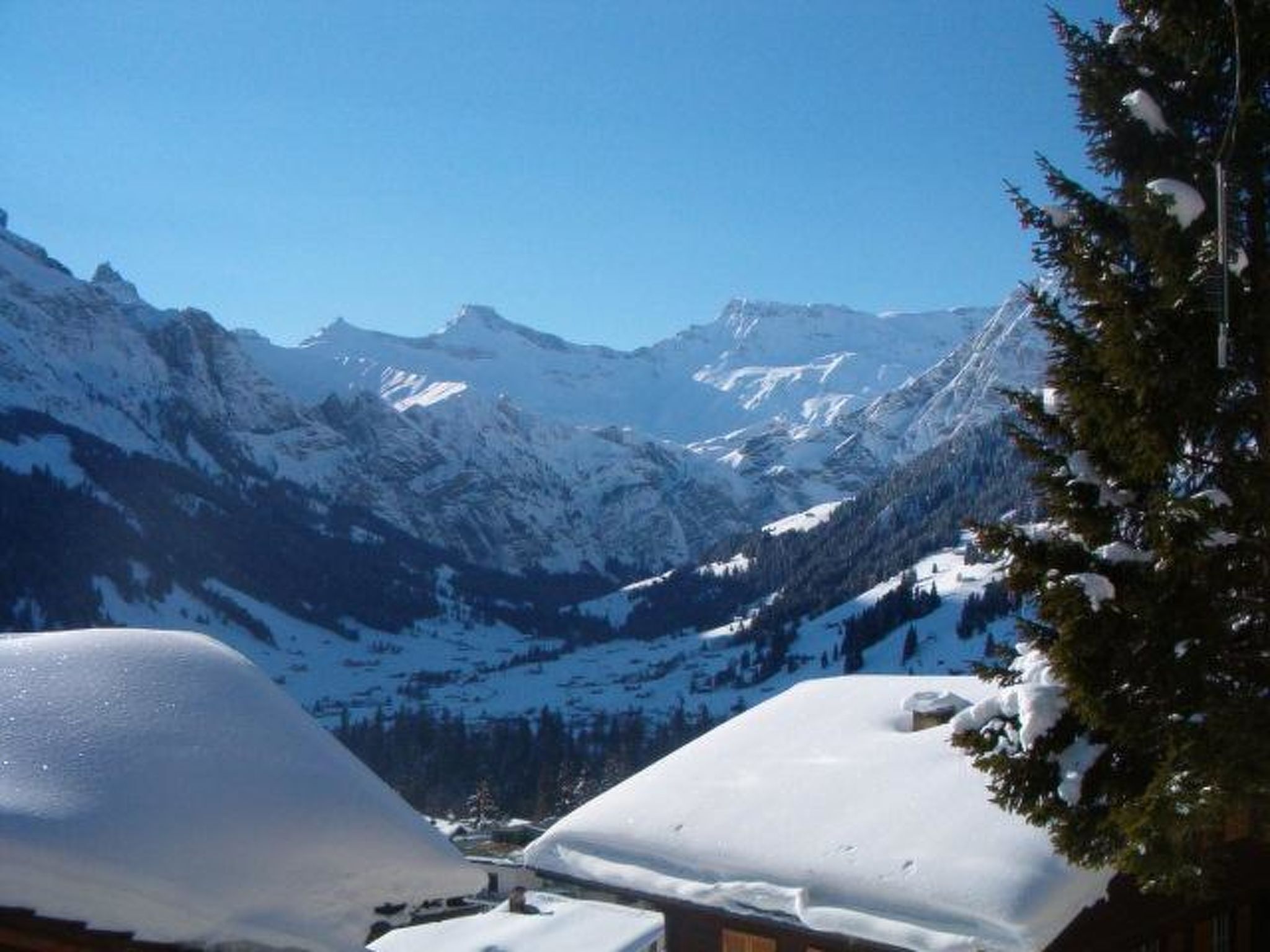 A mountain landscape with snow-covered peaks and a clear sky.