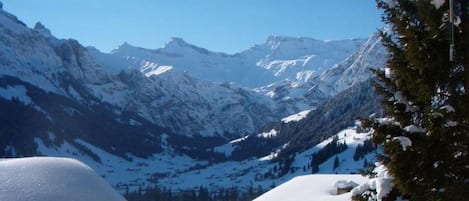 A mountain landscape with snow-covered peaks and a clear sky.