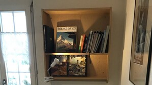 Une pièce avec un lit, une bibliothèque remplie de livres et une fenêtre.