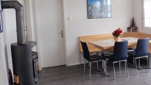 Un coin repas avec une table et des chaises, un tableau au mur et une cheminée.