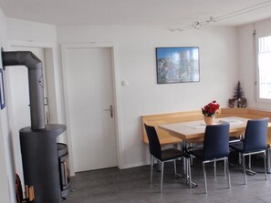 Ein Essbereich mit Tisch und Stühlen, einem Bild an der Wand und einem Kamin.