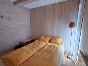 Une chambre à coucher moderne avec un lit, des tables de chevet et une lampe sur pied.