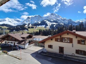 A residential area with houses, a parking lot, and a mountain range in the background. - Chalet Sirius Appartement/Fewo, Bad, WC, 3 Schlafräume 4-Zimmer-Wohnung by Interhome (Adelboden)
