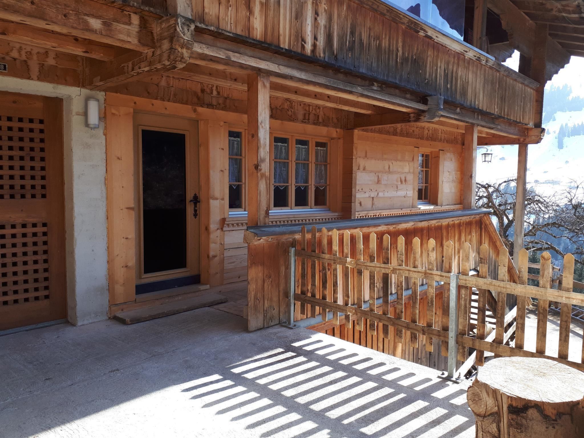 Eine Holzhütte mit Balkon, einer Tür und Fenstern.