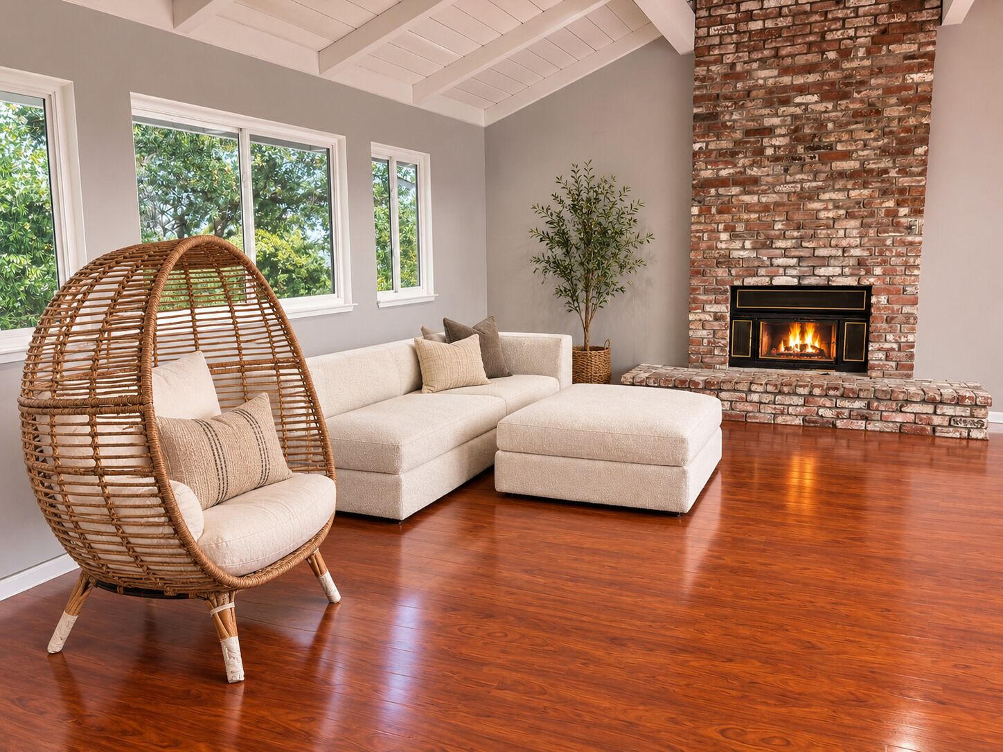 Una sala de estar moderna con un sofá modular, un sillón de mimbre, una chimenea y un ventanal grande.
