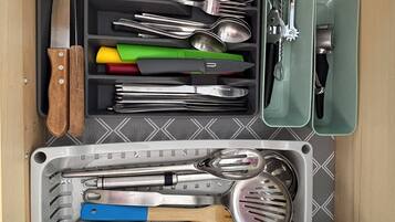 Un cajón con diversos utensilios de cocina organizados en compartimentos.