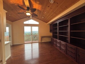 A spacious room with a high ceiling, a ceiling fan, and a large window with a view of the outdoors. - Hidden Vista House, Mountain Views & 2 Primary Suites (Los Gatos)
