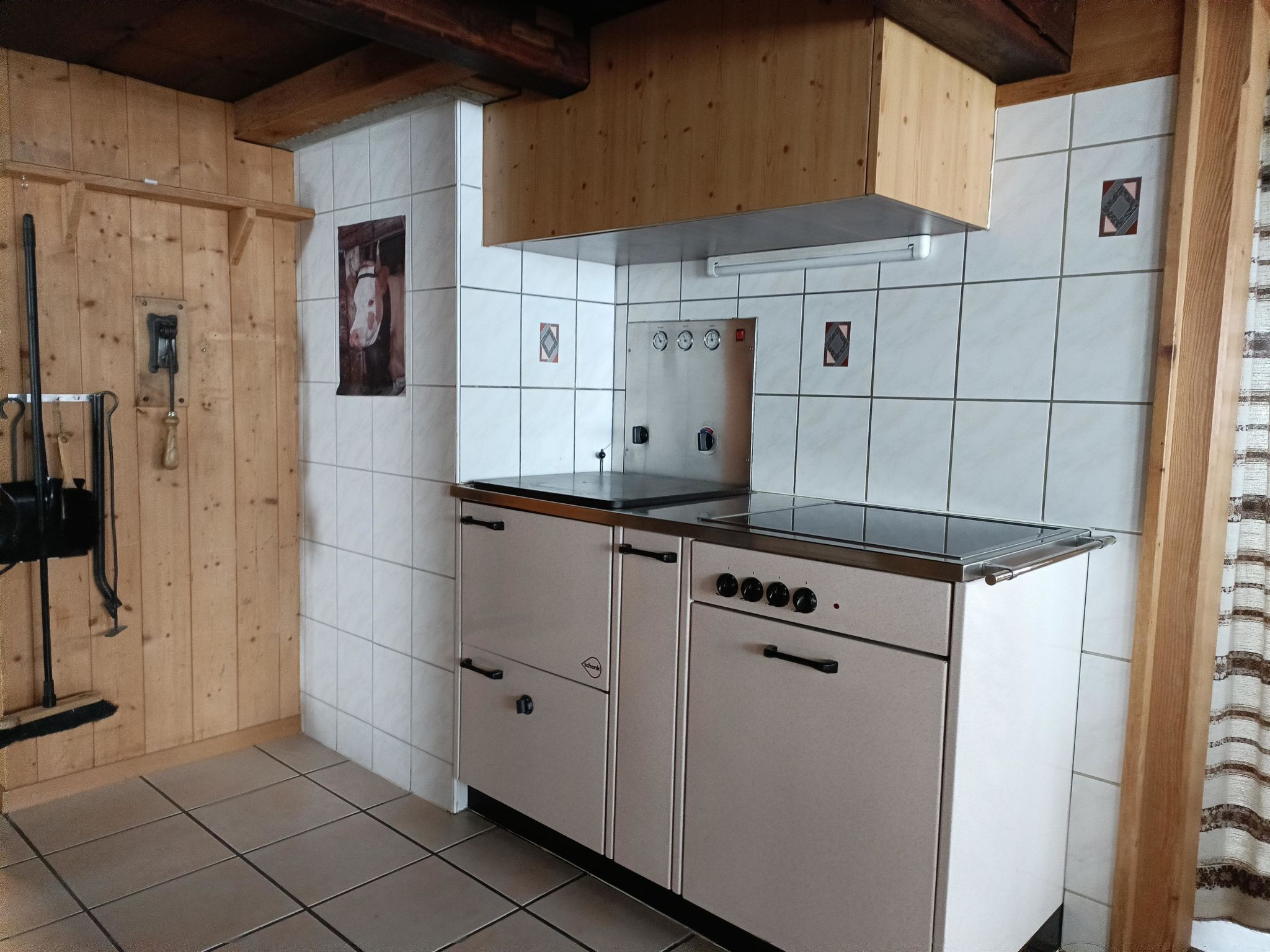 Una cocina con estufa, armarios y salpicadero de azulejos.