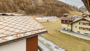 Vuoristokylä, jossa on perinteisiä rakennuksia, urheilukeskus ja näkymä ympäröivään metsään.
