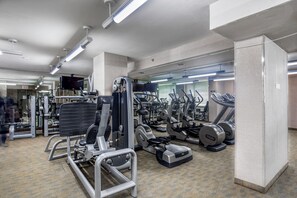 Ein Fitnessstudio mit verschiedenen Trainingsgeräten, darunter Laufbänder und Kraftgeräte.
