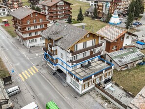 Ein mehrstöckiges Hotel mit Balkonen, einem Parkplatz und einer Straße mit Zebrastreifen.
