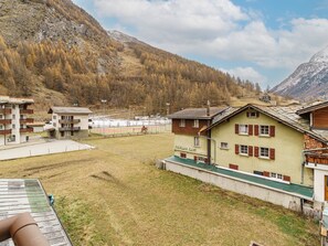 A mountainous area with buildings, a sports field, and a ski slope. - Haus Astoria by Interhome (Saas-Grund)