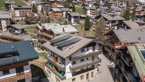 A multi-story building with a ski slope on the roof, surrounded by other residential buildings. - Haus Slalom by Interhome (Saas-Fee)