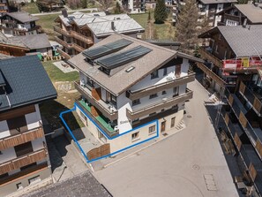Un edificio de varios pisos con techo plano, paneles solares y balcones.