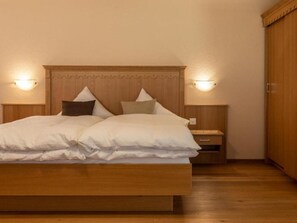 Ein Schlafzimmer mit einem hölzernen Bett, zwei Nachttischen und einem Holzschrank.