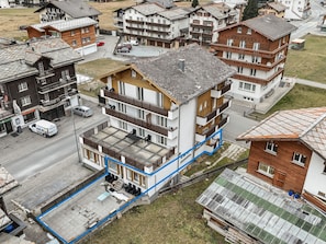 A multi-story residential building with balconies, a covered outdoor area, and a street view. - Haus Astoria by Interhome (Saas-Grund)