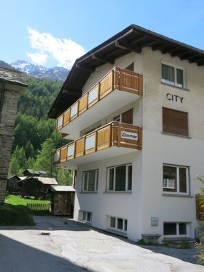 A two-story building with a balcony, labeled 'CITY' and 'Zimmer.' - Haus City by Interhome (Saas-Grund)