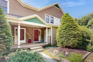 A two-story house with a covered porch, a red door, and a green roof. - Cozy Newry Condo Near Sunday River | Sleeps 8 | Fireplace (Newry)