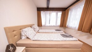 A bedroom with a bed, bedside table, and a view of the outside. - Haus Astoria by Interhome (Saas-Grund)