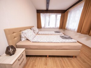 A bedroom with a bed, bedside table, and a view of the outside. - Haus Astoria by Interhome (Saas-Grund)