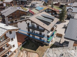 A multi-story building with balconies, a rooftop terrace, and a small courtyard. - Haus Slalom by Interhome (Saas-Fee)