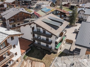 A multi-story building with balconies, a green roof, and a stone facade. - Haus Slalom by Interhome (Saas-Fee)