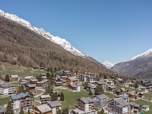 A mountain village with chalet-style buildings, a ski resort, and snow-capped mountains in the background. - Haus Slalom by Interhome (Saas-Fee)
