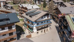 A multi-story building with a modern design, featuring balconies and a flat roof with solar panels. - Haus Slalom by Interhome (Saas-Fee)